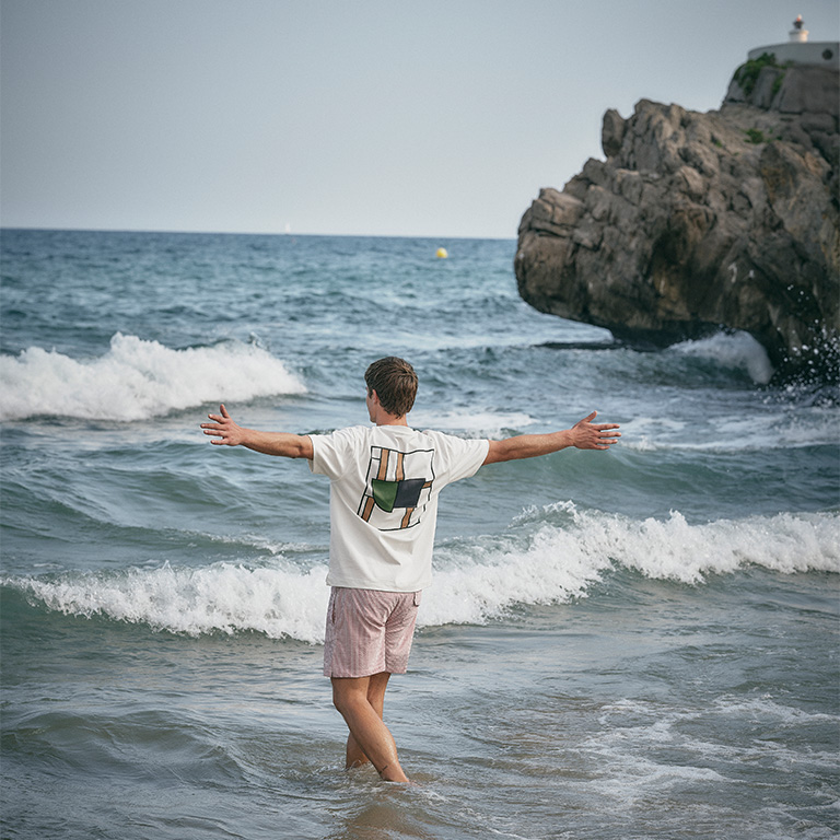 man lopend door zee met zijn armen gespreid