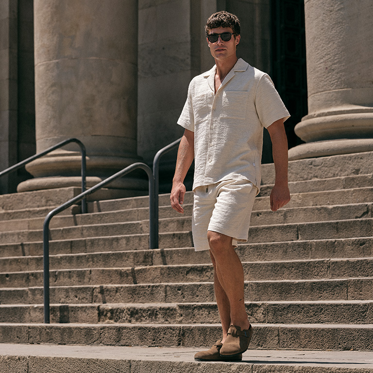 Man lopend in een co-ord outfit van een trap af