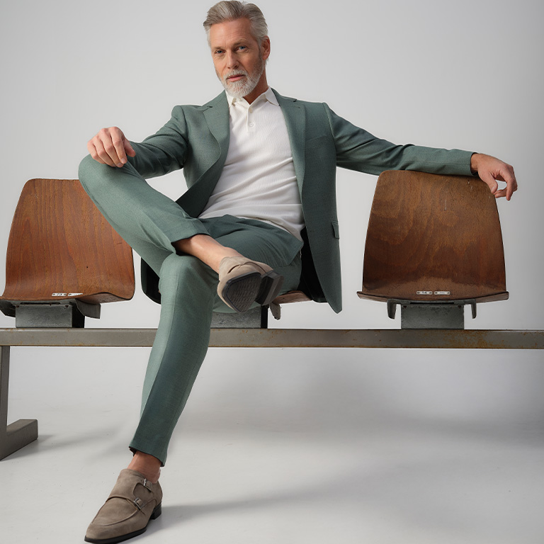 man zittend in een groen pak op gym stoelen