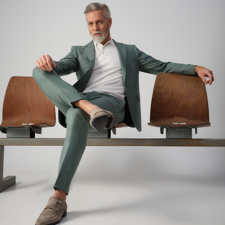 man zittend in een groen pak op gym stoelen