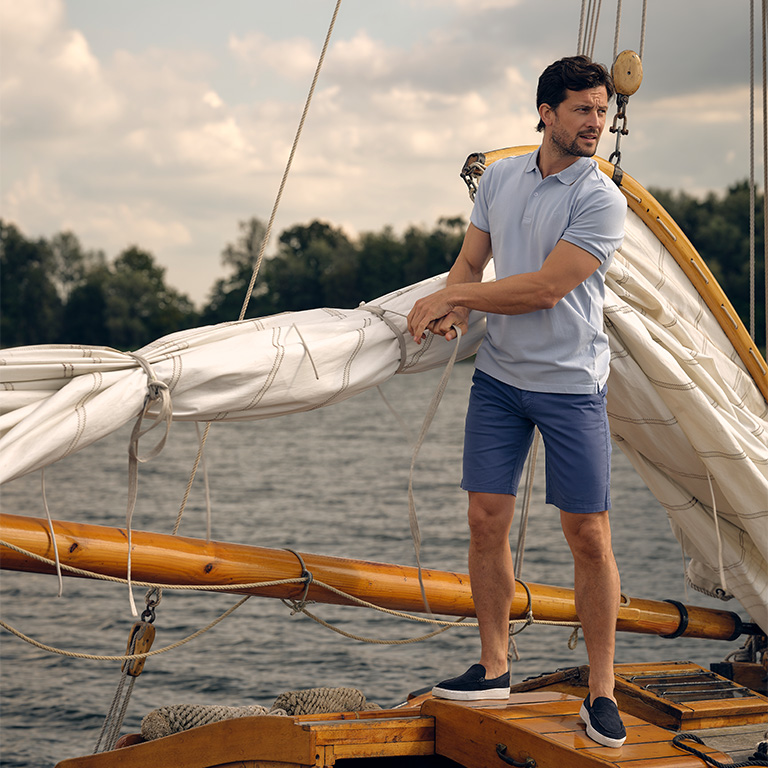 Man die staat op een zeilboot