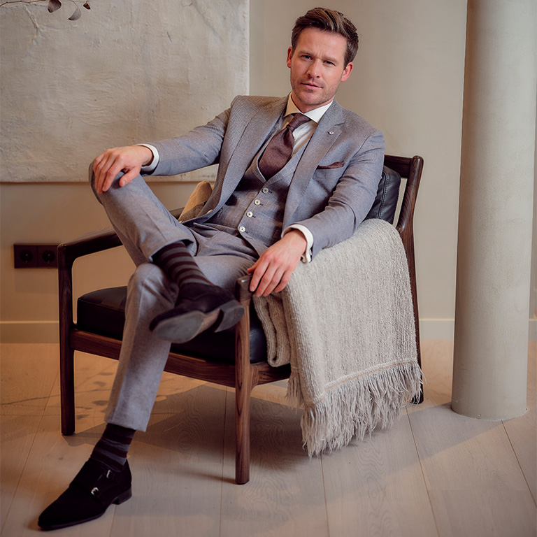 Afbeelding van een man in trouwpak zittend in een stoel