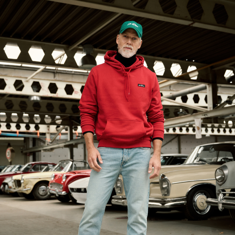 man gekleed in een rode hoodie en een lichtblauwe jeans