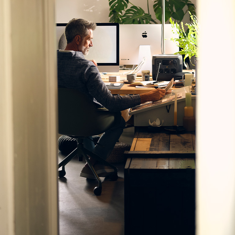 man zittend achter zijn bureau op kantoor