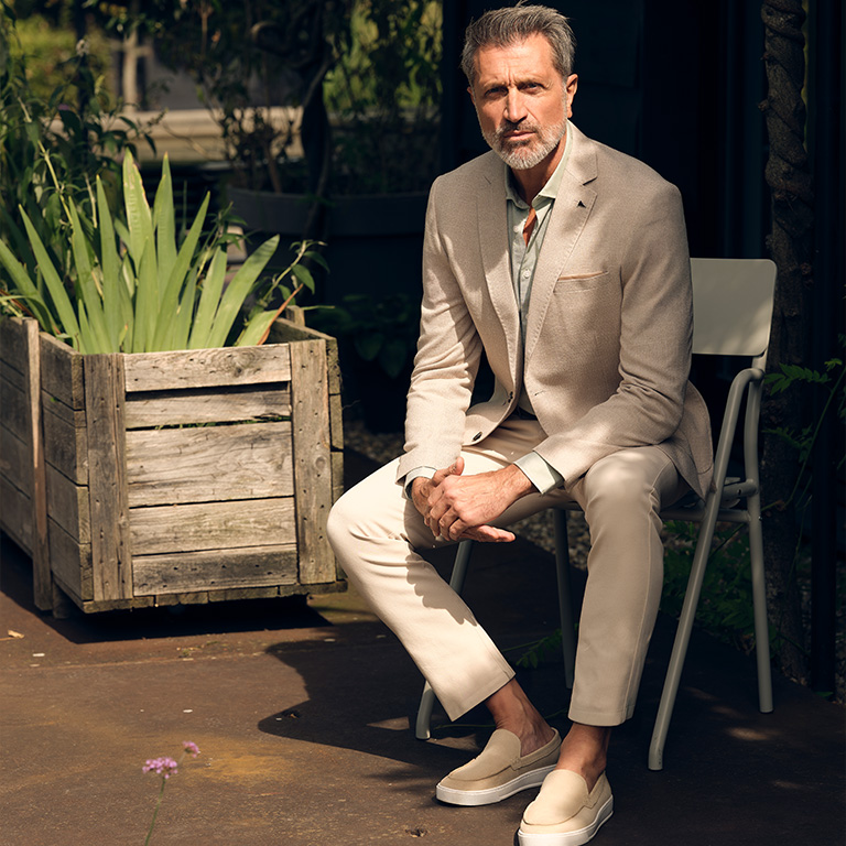 Man die zit op een stoel gekleed in pak