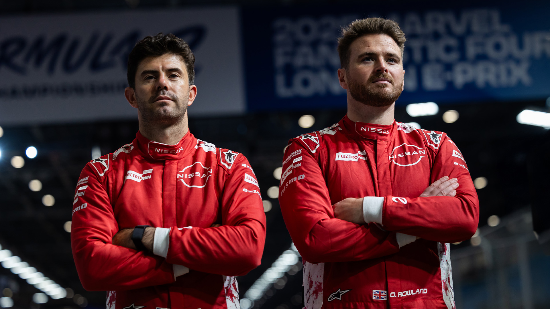 Norman Nato (left) and Oliver Rowland (right) wearing their red Nissan Formula E race suits and standings with arms crossed