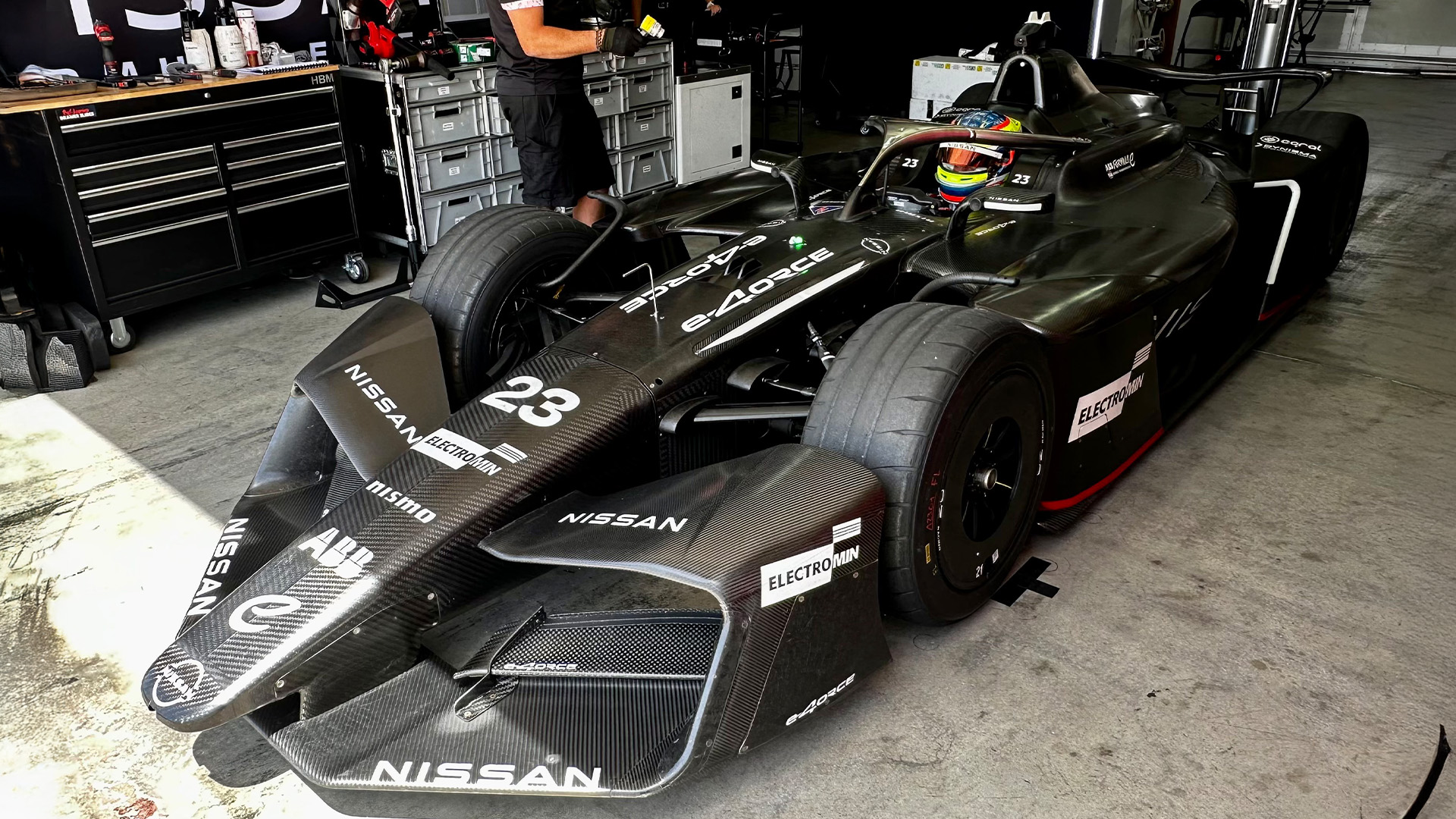 Oliver Rowland sits in the Nissan Formula E Team GEN4 car in the garage