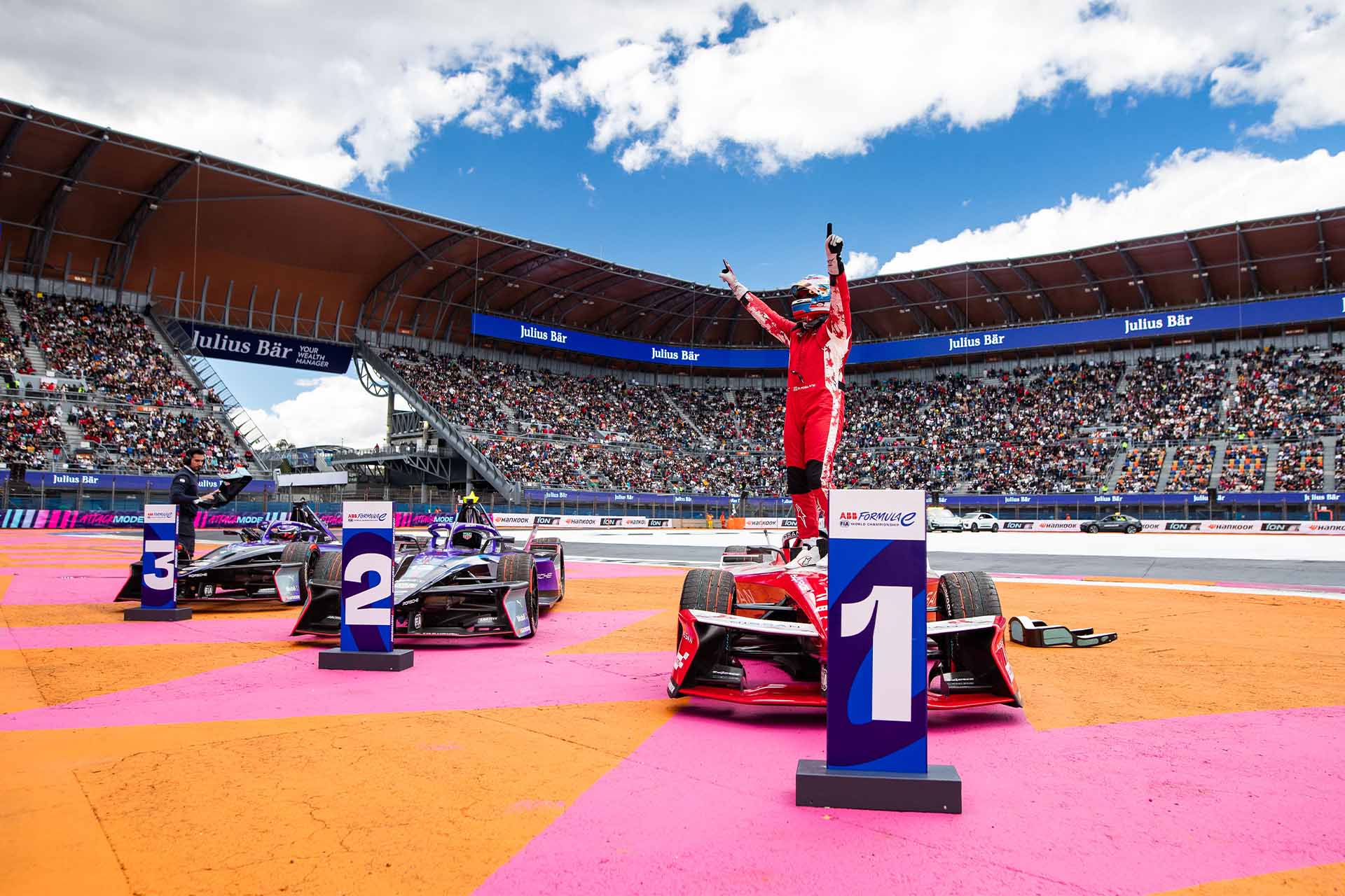 Oliver Rowland stands on his car in front of the number 1 pit board, celebrating his win in Mexico City