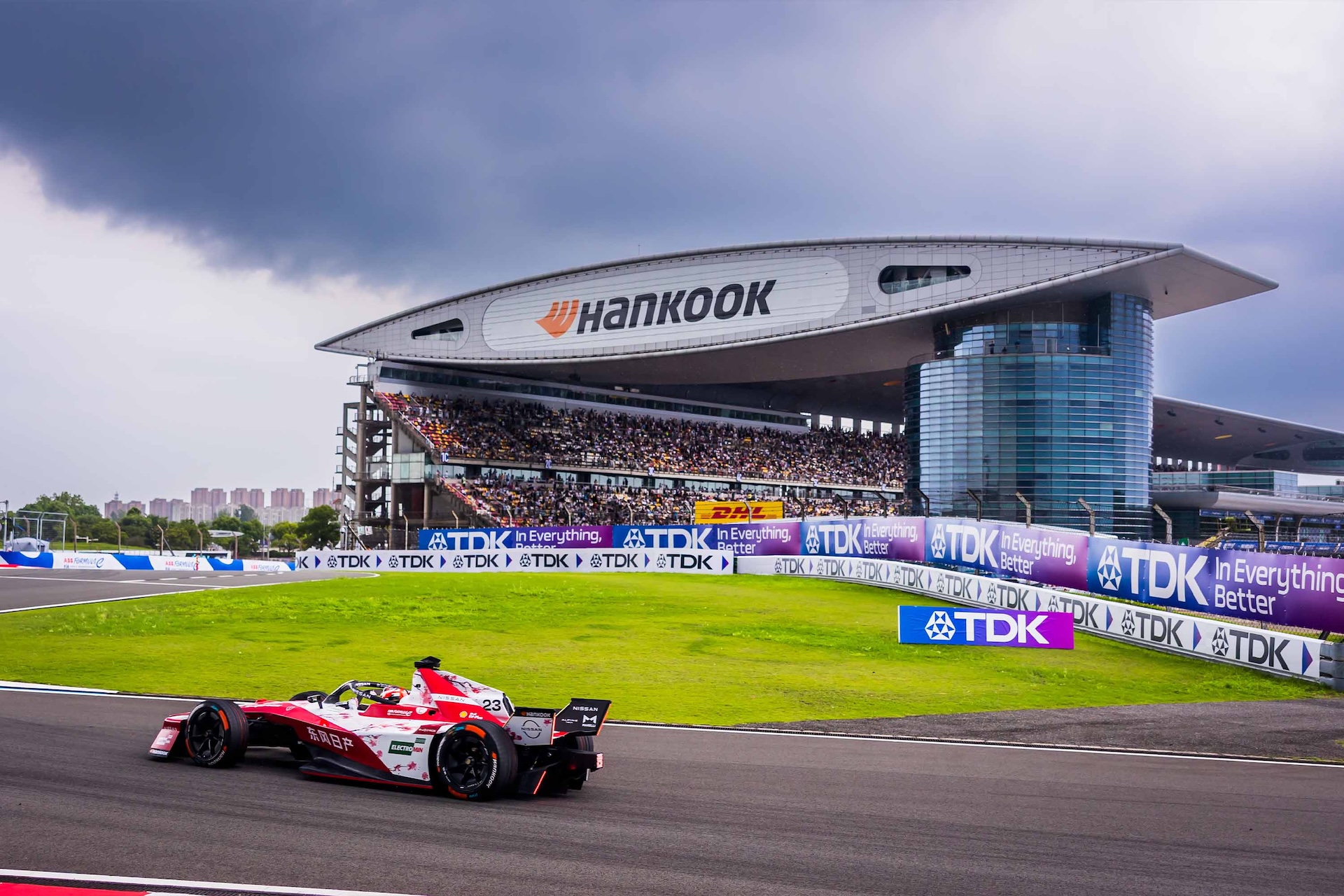 Rear shot of Norman Nato in the #23 Nissan e-4ORCE 05 with the Shanghai grandstand in the background.