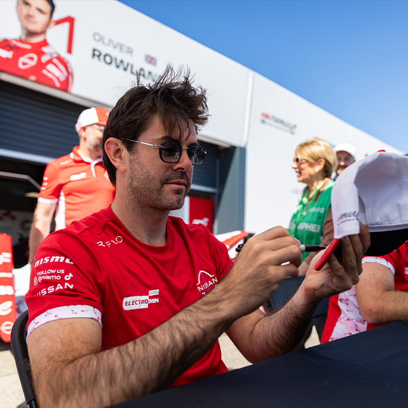 Norman Nato signs a cap for a fan