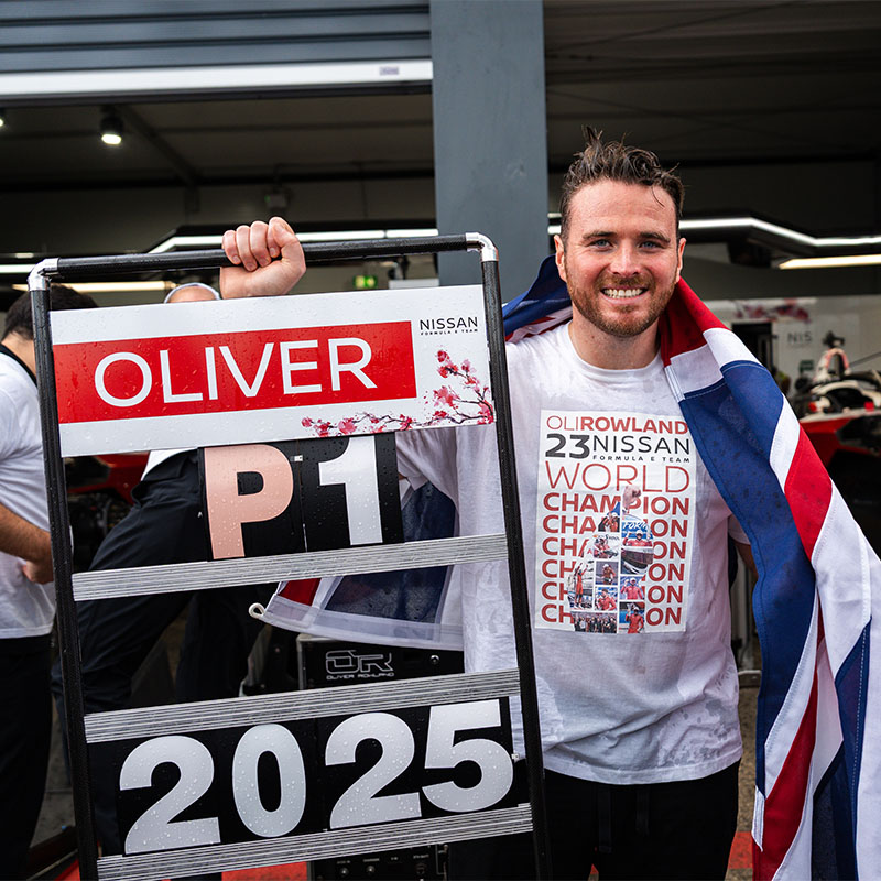 Oliver Rowland celebrates his world title with a pit board that reads 'Oliver P1 2025'