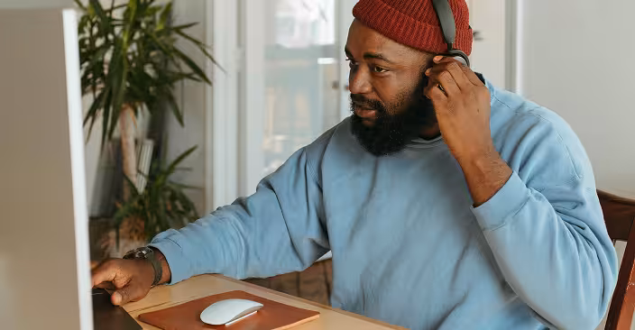 Man looking at his phone wearing headphones