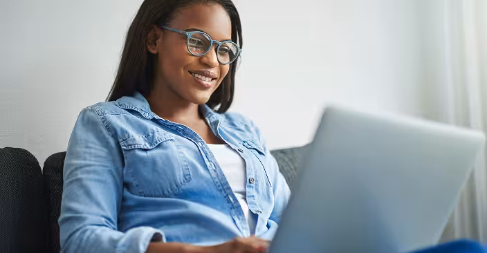 Woman using a laptop on a sofa