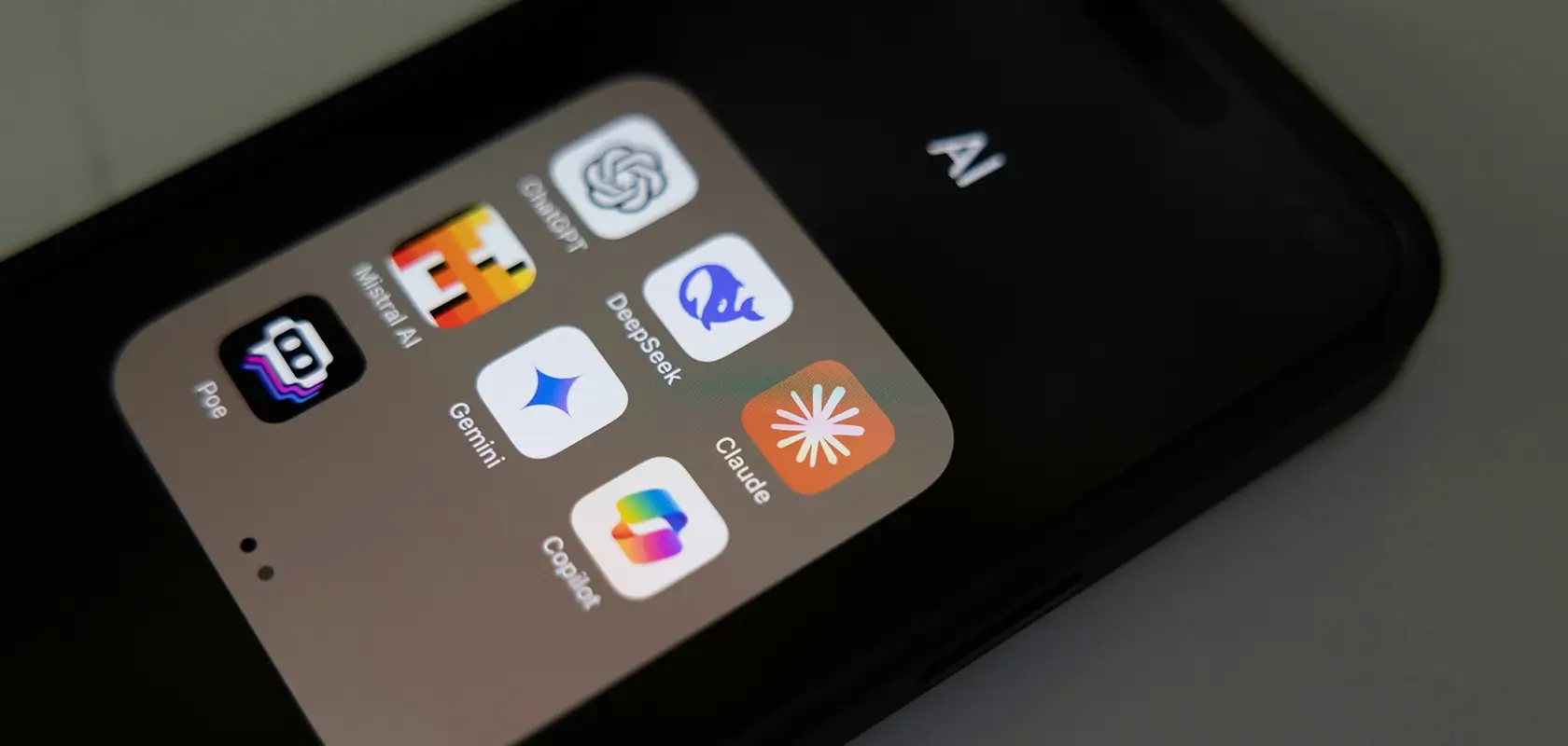 Smartphone screen displaying various AI app icons, including colorful logos on a minimalistic background.