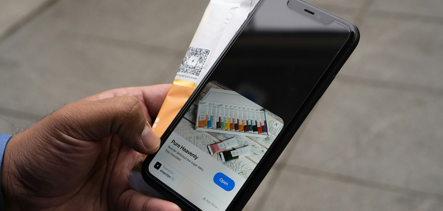 Eine Person mit einem Smartphone, auf dem eine digitale Bordkarte und eine Flugroute auf einer Karte angezeigt werden.