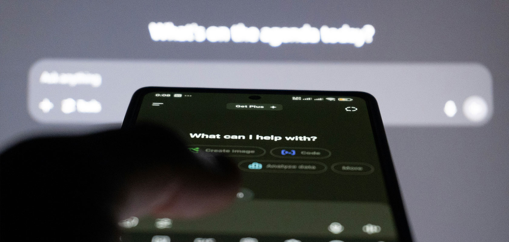 Ein Smartphone-Bildschirm, auf dem eine digitale Assistenzschnittstelle mit dem Text „Womit kann ich Ihnen helfen?“ und einem unscharfen Hintergrund angezeigt wird.
