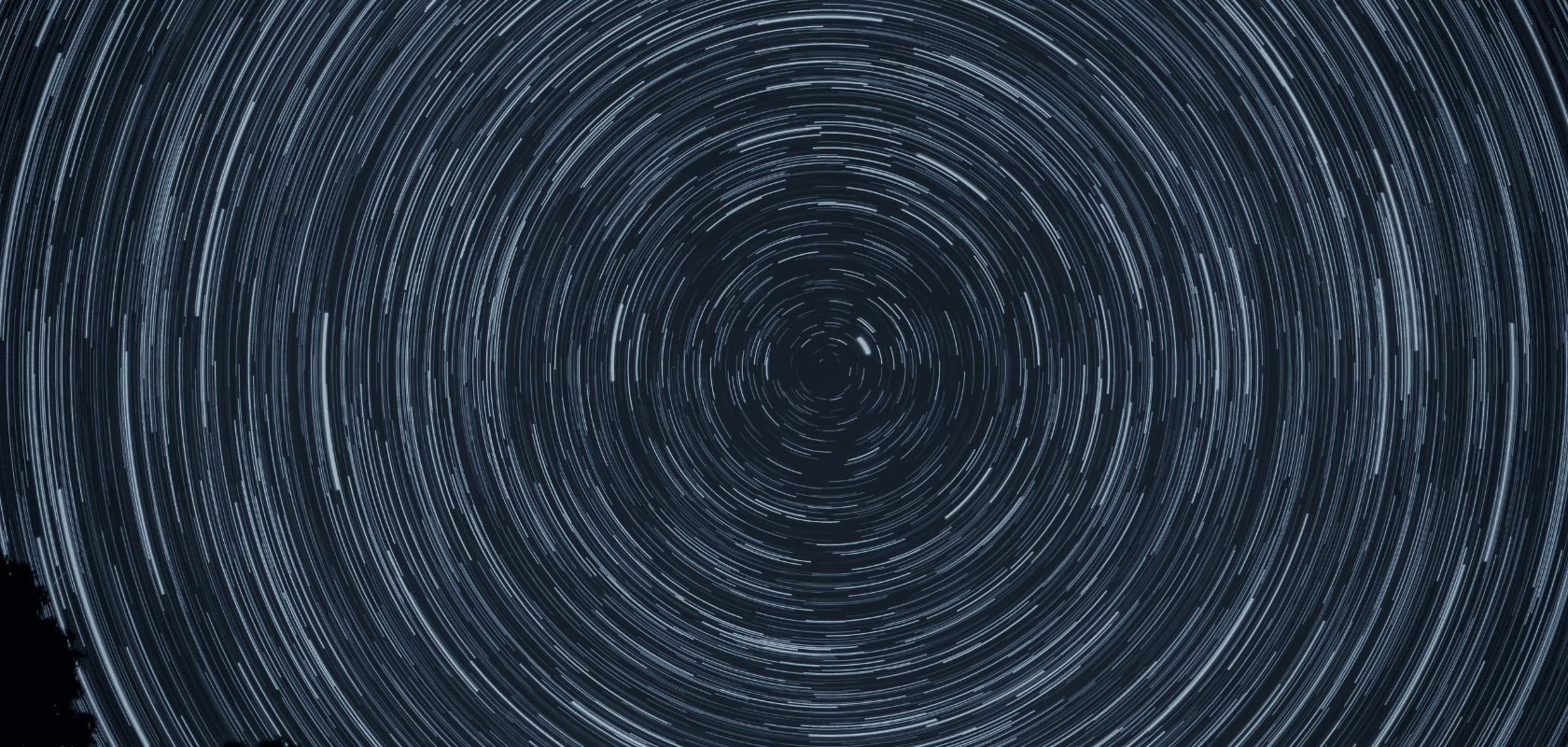 Langzeitbelichtung des Nachthimmels mit kreisförmigen Startrails (Sternspuren) um den Polaris.