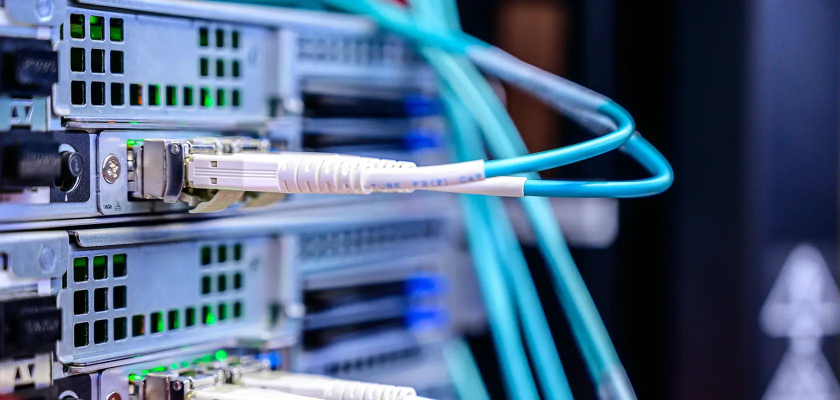 Network cables connected to servers in a data center, with LED indicators lit, highlighting a high-tech environment.
