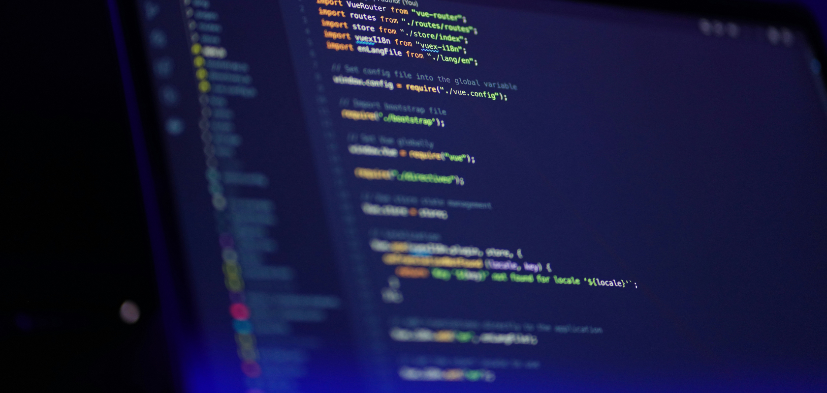 Nahaufnahme eines Computerbildschirms, auf dem bunte JavaScript-Codezeilen in einer dunklen Umgebung zu sehen sind.