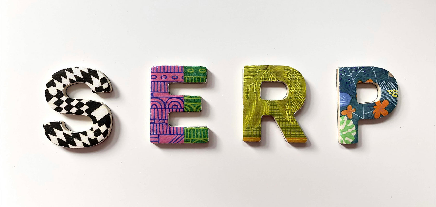Bunte Buchstaben „SERP“ mit jeweils einzigartigen Mustern auf weißem Hintergrund.