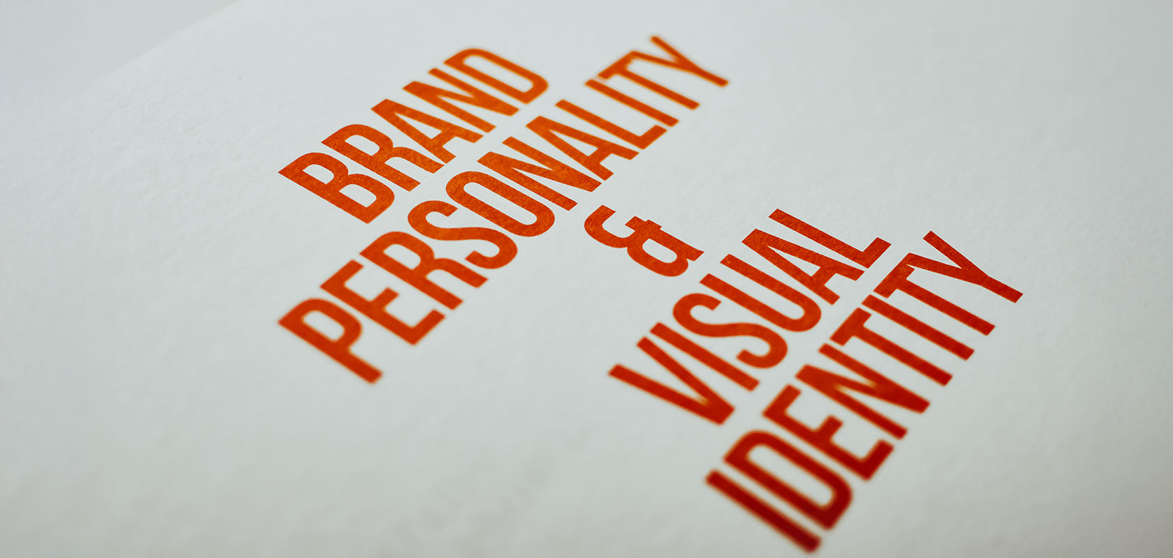 Roter Aufdruck „Brand Personality & Visual Identity“ auf weißem Papier.