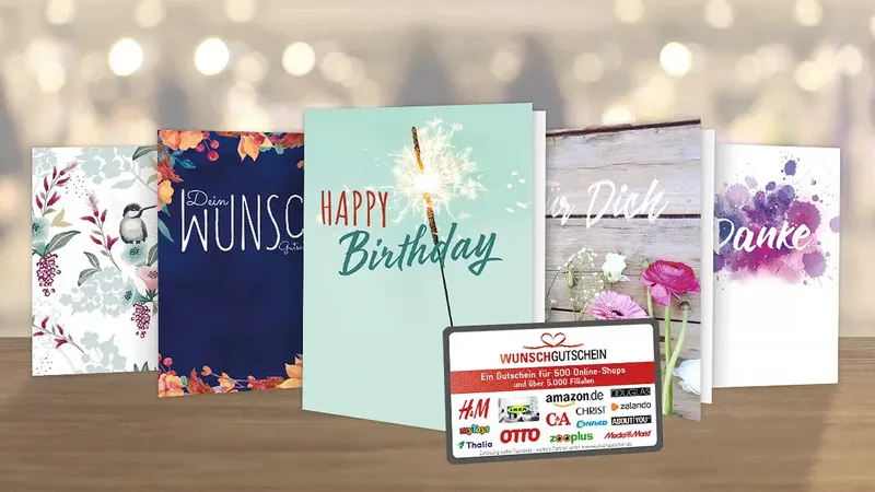 Eine Vielzahl von Grußkarten mit Blumenmotiven und eine Geschenkkarte mit mehreren Geschäftslogos, die auf einer Holzfläche ausgestellt sind.