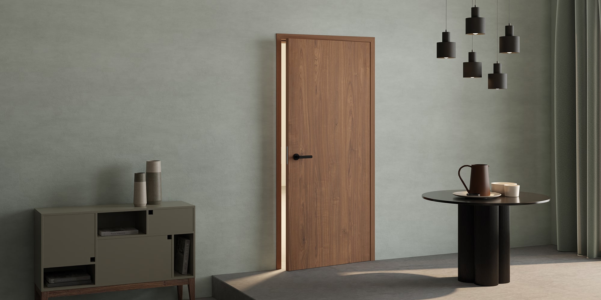 Minimalistischer Raum mit einer Holztür, einem schwarzen runden Tisch, Pendelleuchten und einem Sideboard mit Vasen vor einer hellen Wand.