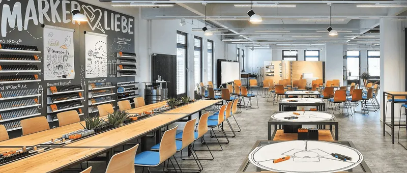 Heller, kreativer Arbeitsraum mit Arbeitstischen und Regalen voller Stifte