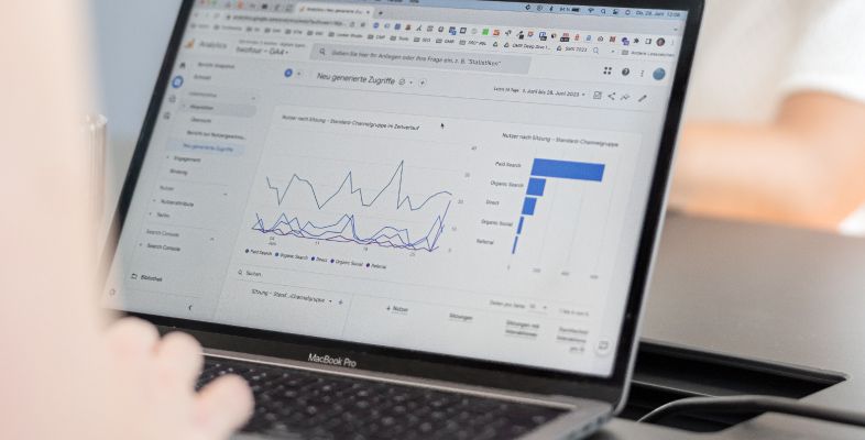 Ein Laptop zeigt Webanalyse-Daten mit Diagrammen zu Website-Zugriffen und Nutzerverhalten