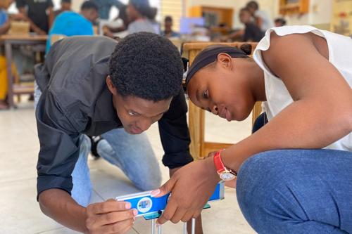 Students building robotics hardware during a maker-lab session in Port-au-Prince, Haiti.