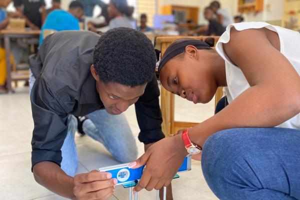 Students building robotics hardware during a maker-lab session in Port-au-Prince, Haiti.