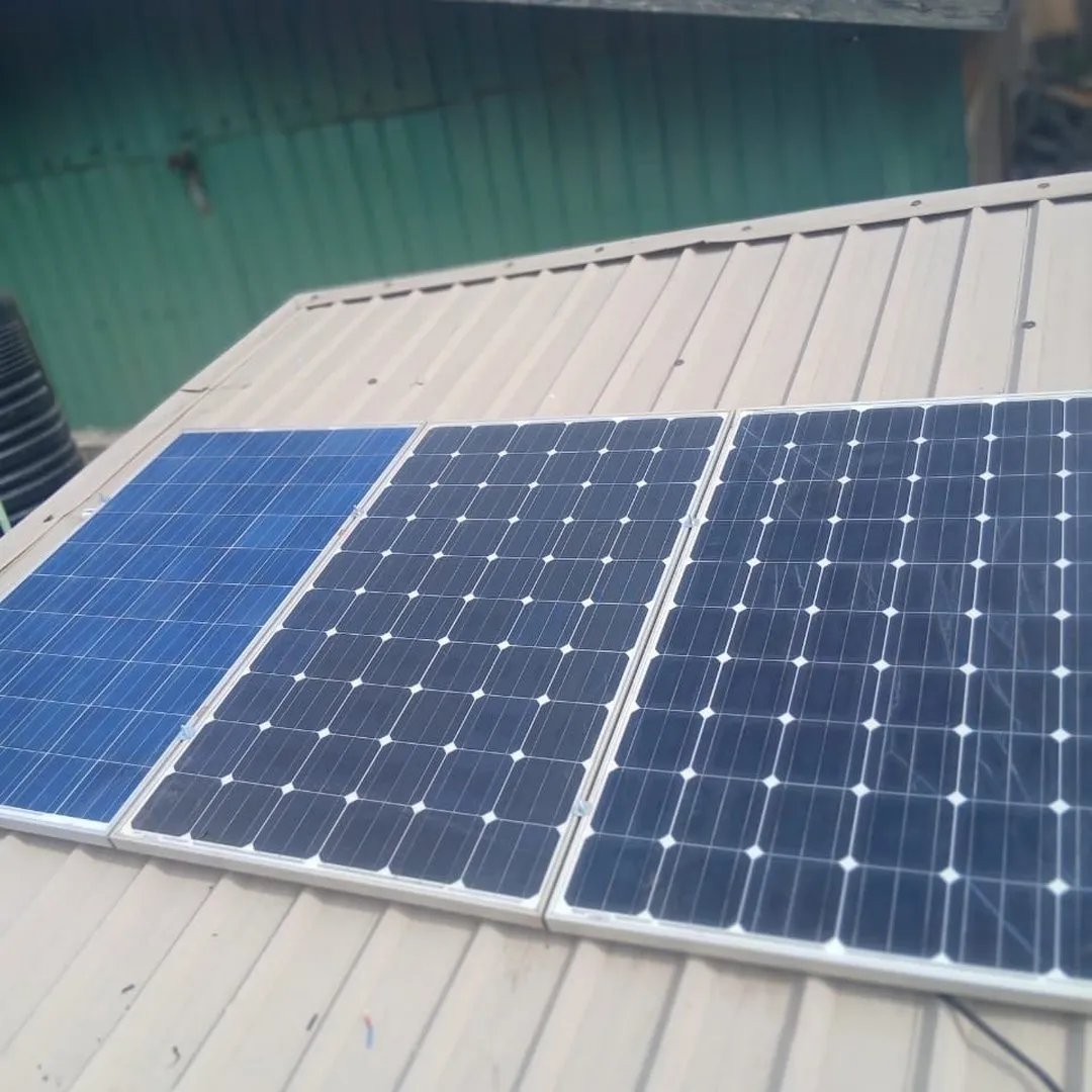 A technician installing wiring for the solar panel system on the clinic roof.