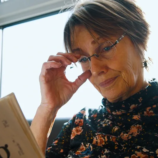 Ältere Frau beim Lesen mit Brille – Informationen zur Grauer Star OP in Ihrer Nähe.