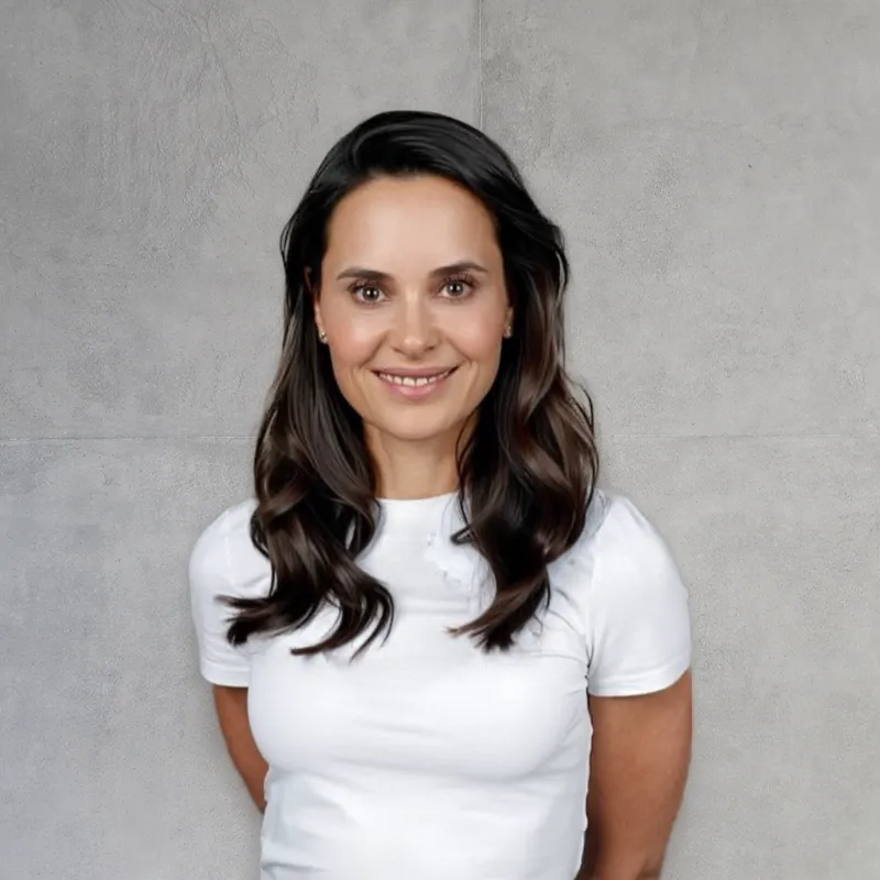 Smile Eyes Augenärztin Dr. med. Natalie Minko aus Berlin, die lächelnd in einem hellen, modernen Büroraum steht.