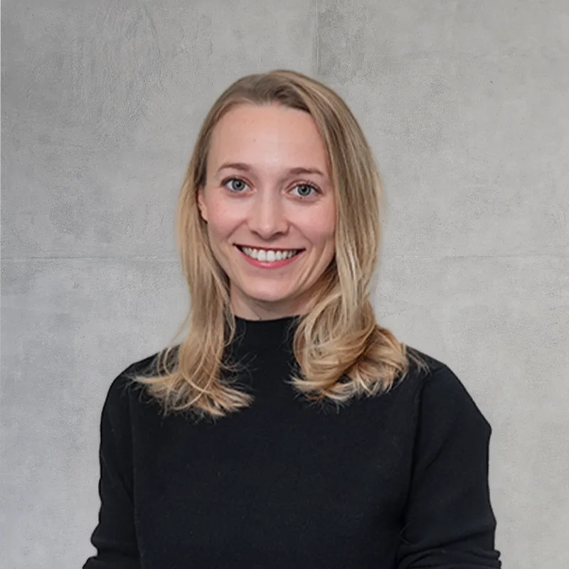 Smile Eyes Augenärztin Lydia Schwer, die lächelnd in einem hellen, modernen Büroraum steht.