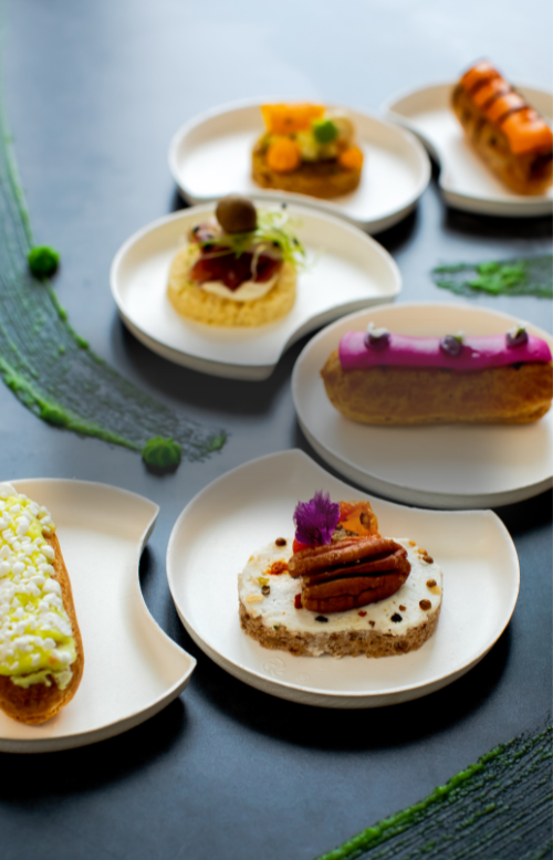 Speisen liegen auf aneinander passenden Tellern auf einem Tisch