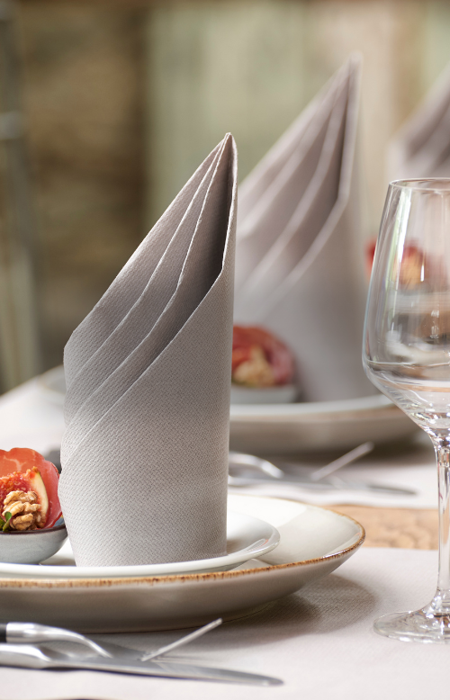 gefaltete Serviette auf einem gedeckten Tisch