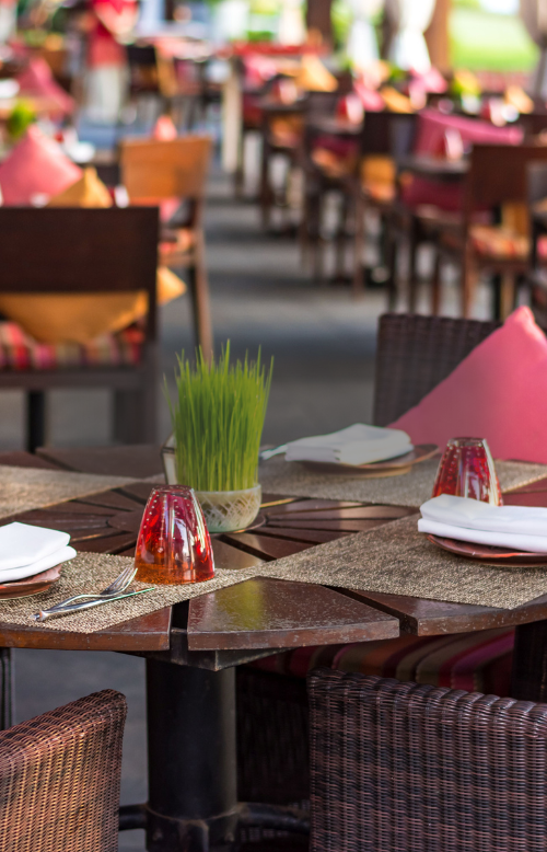 Tische und Stühle auf einer Restaurantterasse