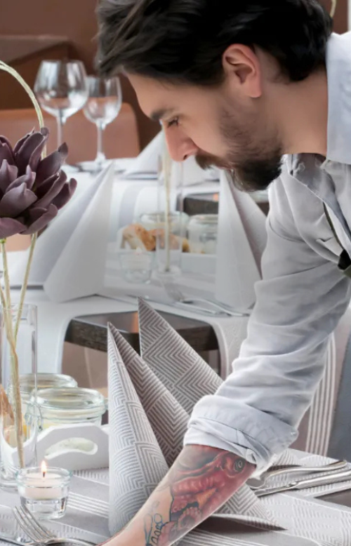 Kellner deckt einen Tisch in einem Hotel ein