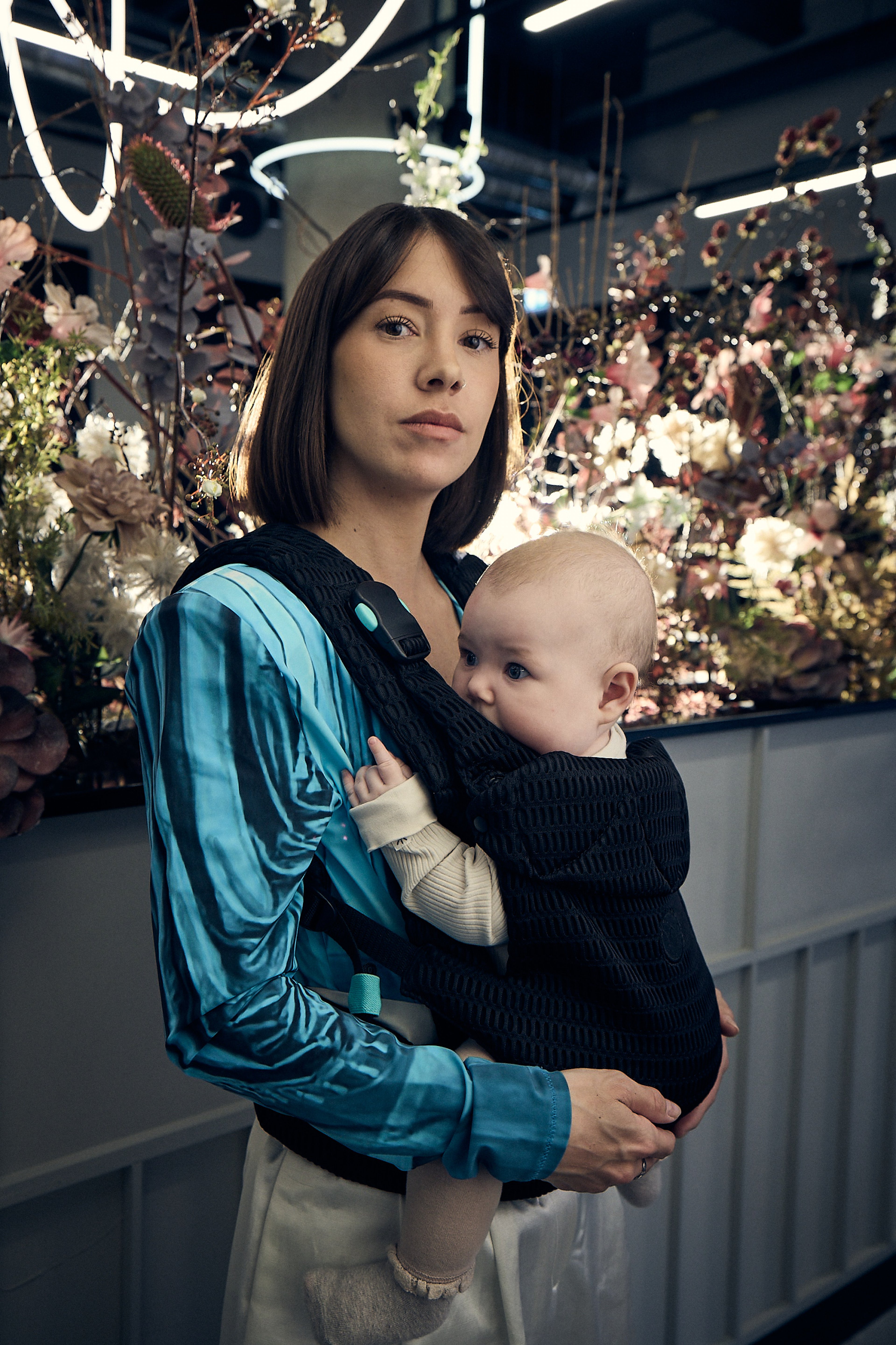 Person carrying a baby in a black Najell Rise baby carrier