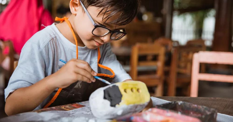 menino pintando uma porcelana