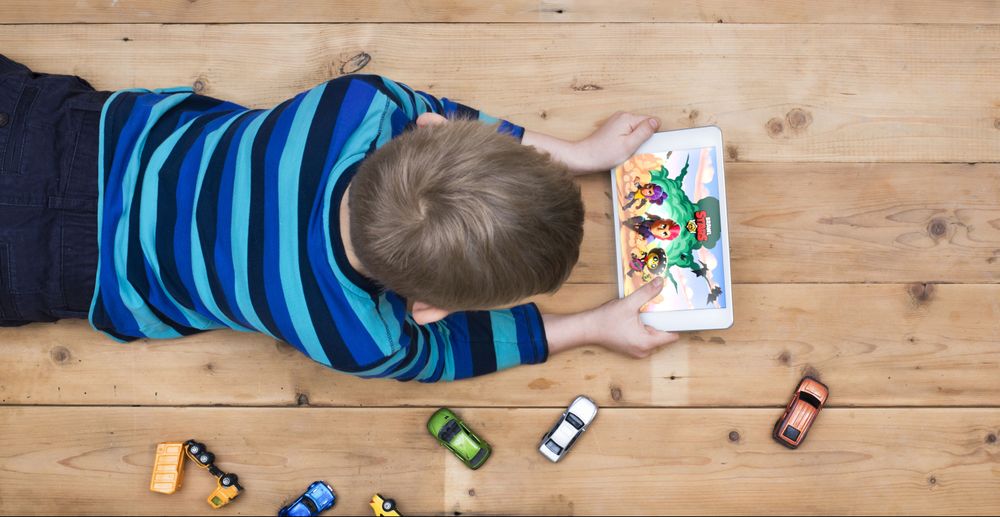 Boy playing Brawl Stars on his tablet on the floor