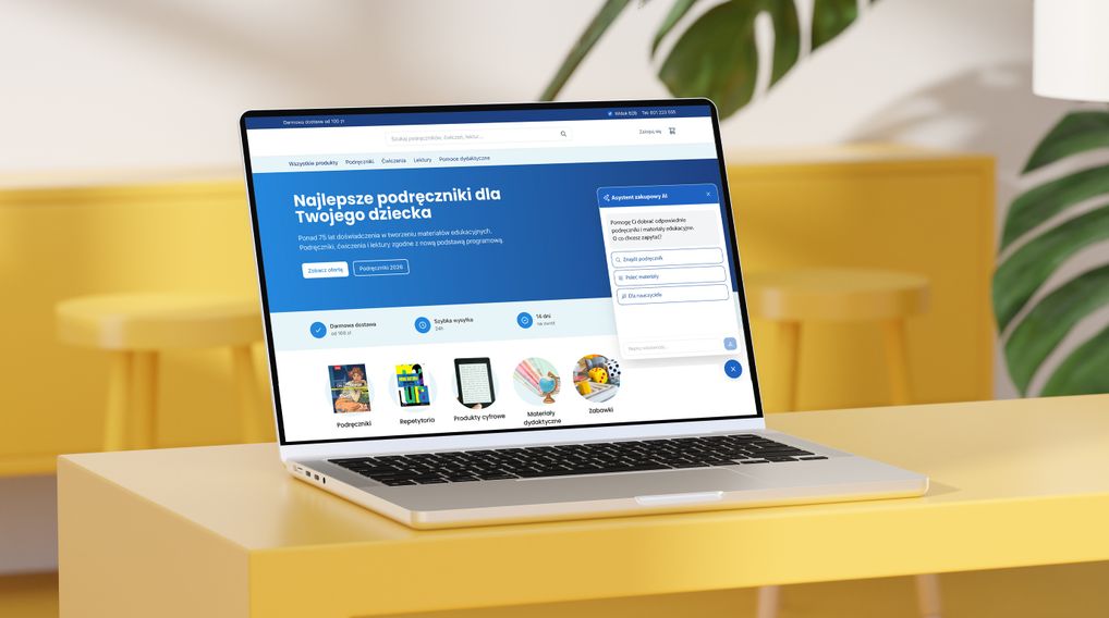 A laptop displaying a website for educational materials and textbooks in Polish, set on a yellow table with blurred background elements.