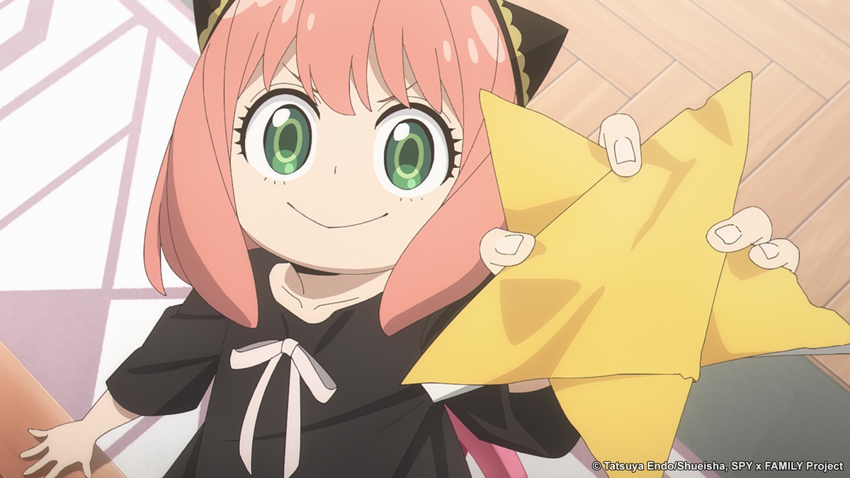 أنيا وهي تحمل بيدها نجمة صنعتها من الورق وتبدو عليها ملامح الفخر والسعادة في مشهد من انمي SPY x FAMILY