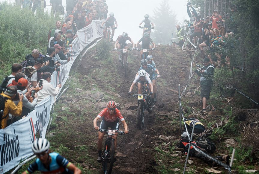 Caroline Bohé cycling downhill over tree roots in Snowshoe USA