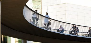 Menschen fahren Fahrrad in der Stadt über eine Brücke.