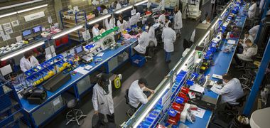 Arbeiter in einer Fabrikhalle für elektrische Fahrzeuge.