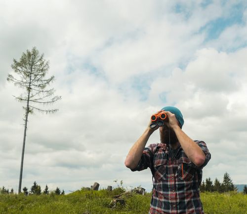 male-hiker-using-binoculars-outdoors-2021-08-26-15-50-19-utc