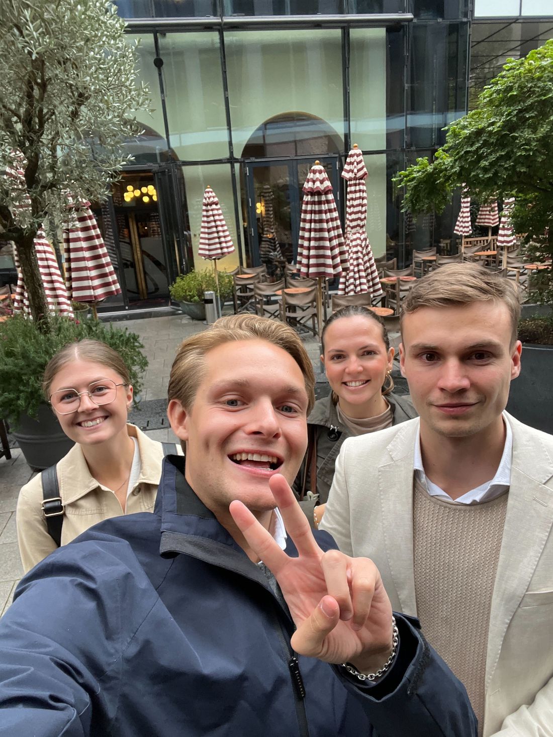 Four colleagues taking a selfie outside a restaurant