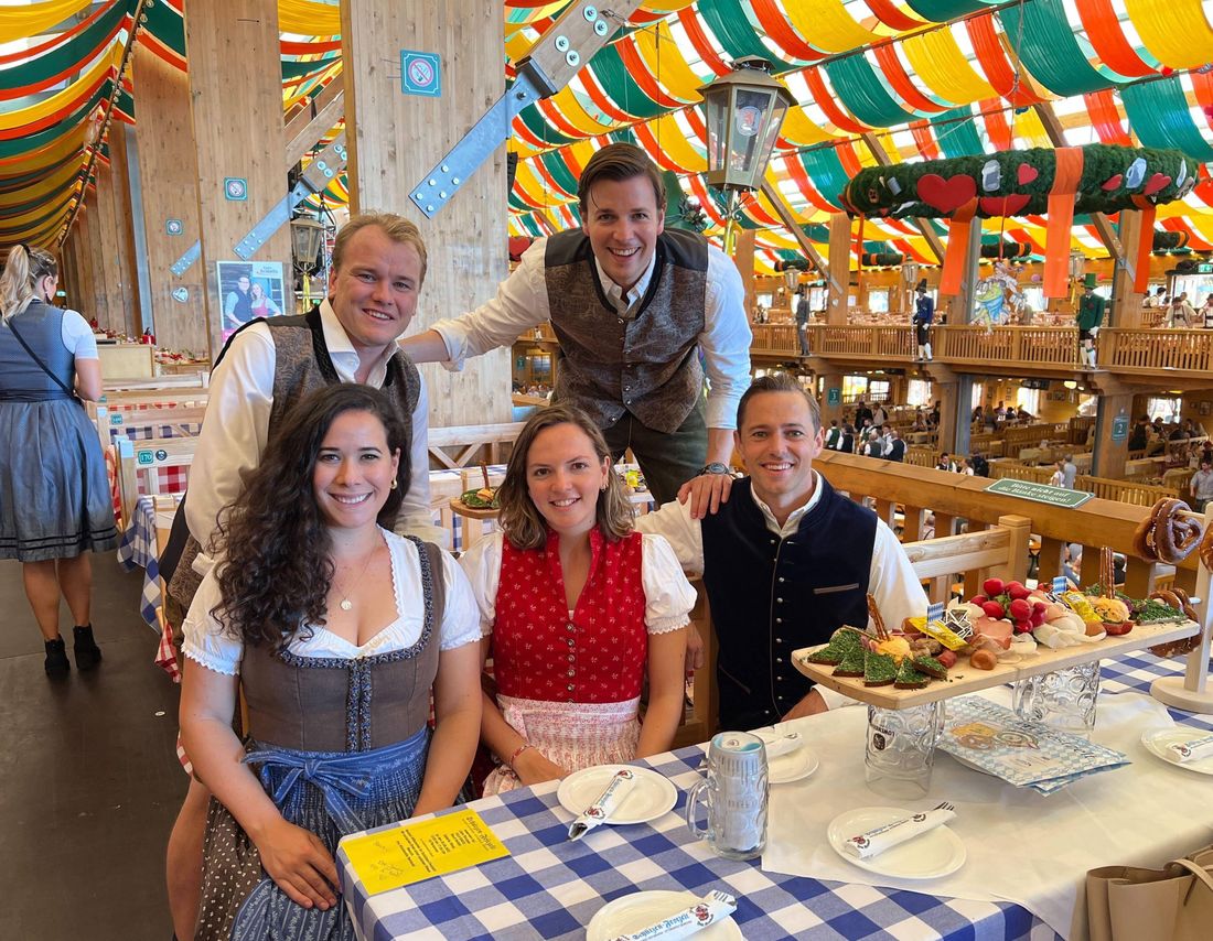 Colleagues in traditional Bavarian dress at a festival table